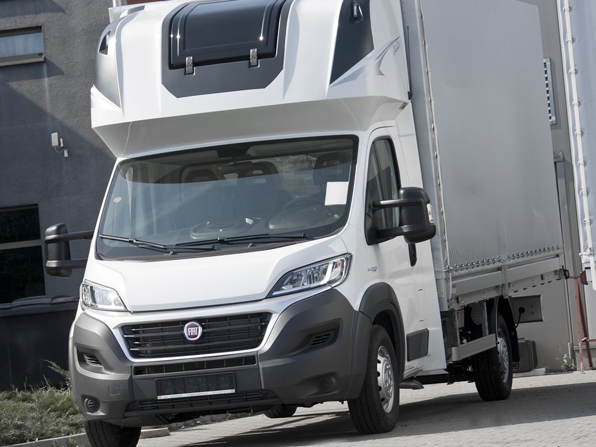 Biały Fiat Ducato z zabudową skrzyniową i plandeką
